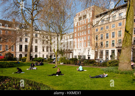 On a warm, sunny day in March, people are out in St James's Square London enjoying the sunshine Stock Photo