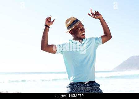 Portrait of young african man having fun at the beach on summer day Stock Photo