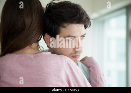 Young couple hugging, woman embracing comforting man, wife conso Stock Photo