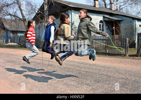 Tver, Russia - May 2, 2006: Russian, rural junior schoolchildren during recess, jumping rope, on the road near the school Stock Photo
