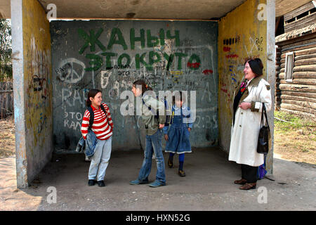 Tver, Russia - May 2, 2006: Rural areas in Russia, schoolgirl bus are waiting at the bus stop Stock Photo