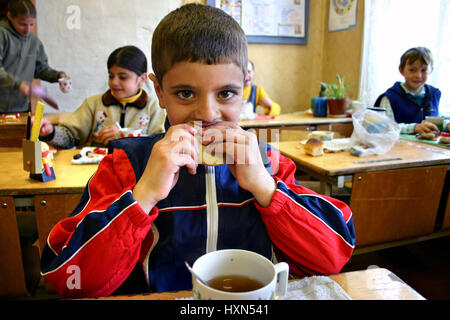 Tver, Russia - May 2, 2006: Dinner time at a rural school, schoolchild eating lunch in the classroom. Stock Photo