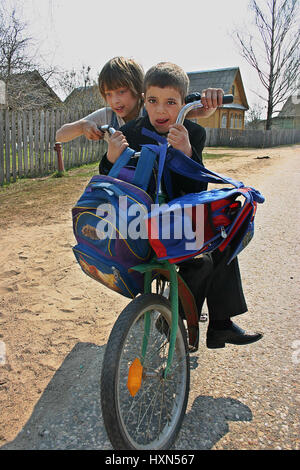 Podol village, Tver region, Russia - May 5, 2006: The pupils of junior classes of rural school on a bike ride together. Stock Photo