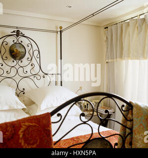 Four poster bed in bedroom with red accents. Stock Photo