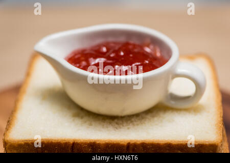 Toast with strawberry jam on a plate on table. Stock Photo