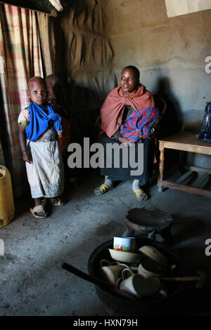 Meserani Snake Park, Arusha, Tanzania - February 14, 2008: The interior of the home maasai, internal view of the hut, a black woman and children Afric Stock Photo