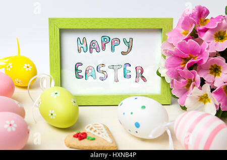 Happy Easter card in a wooden frame with colorful eggs Stock Photo