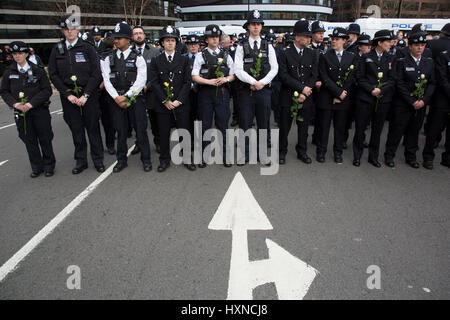 Thousands of people including police officers and Muslim faith leaders gathered on Westminster Bridge to hold a vigil and a minutes silence one week after the terror attack, on March 29th 2017 in London, United Kingdom. Metropolitan Police stand in lines holding white roses in memory of their colleague and members of the public. Stock Photo