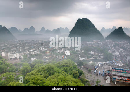 YANGSHUO TOWN , GUANGXI, CHINA - APRIL 1, 2010: Springtime in South-west China, foggy morning in small town Yangshuo, city located among the karst hil Stock Photo