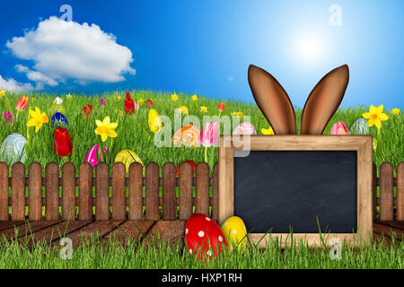 easter bunny ears behind meadow with colorful decorated painted eggs empty blackboard wooden jetty tulips daffodils in front of blue sky panorama back Stock Photo