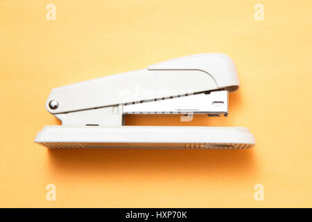 Stapler on orange background Stock Photo