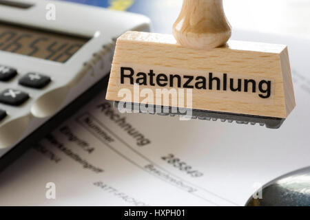 Stamp with label Payment by instalments hangs on stamp circular flower bed, Stempel mit Aufschrift Ratenzahlung hängt an Stempelrondell Stock Photo