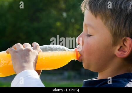 seven-year-old boy drinks from a bottle (mr), siebenjähriger Junge trinkt aus einer Flasche (mr) Stock Photo