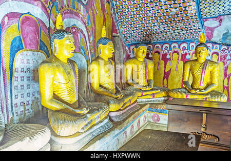 DAMBULLA, SRI LANKA - NOVEMBER 27, 2016: The statues of Buddha, surrounded by preserved old patterns on walls of Paccima Viharaya (Western Temple) of  Stock Photo