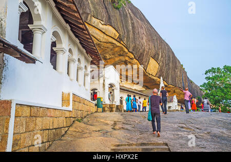 DAMBULLA, SRI LANKA - NOVEMBER 27, 2016: The courtyard of Dambulla Cave Monastery with numerous tourists, enjoying the views of the rock and Temples'  Stock Photo