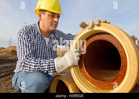 Construction worker works with pipe, Bauarbeiter arbeitet mit Rohr Stock Photo