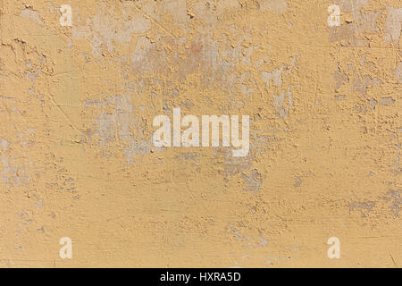 Worn pale yellow wall background, paint partly faded Stock Photo