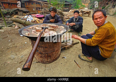 GUIZHOU PROVINCE, CHINA - APRIL 12: Asians, rural Chinese who are sitting on the village street, near the boiler up with boiled pork, April 12, 2010.  Stock Photo