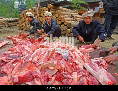 GUIZHOU PROVINCE, CHINA - APRIL 12: Chinese farmers butchering pork on the road in the middle of a rural street, April 12, 2010. Asian pork, Chinese p Stock Photo