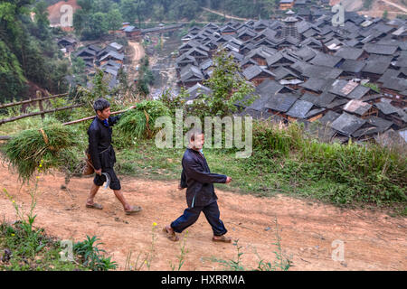 Zengchong Dong Village, Guizhou Province, China - April 11, 2010: Two unidentified Chinese peasants are walking on country road with field work, again Stock Photo