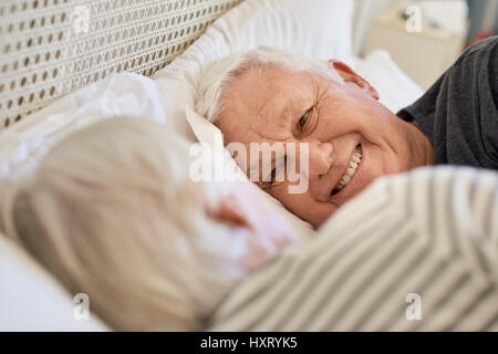 Smiling senior couple looking at each other in bed Stock Photo