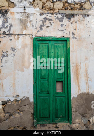 A textured old stone wall with peeling plaster and weathered surface ...