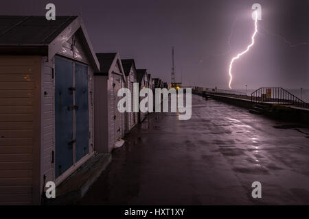 Lightning strike near beach huts and southend on sea coast guard tower, Essex, England Stock Photo