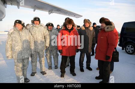 Alexandra Land, Russia. 29th Mar, 2017. Russian Defense Minister Sergei Shoigu, center, waits to greet President Vladimir Putin alongside Prime Minister Dmitry Medvedev, right, after his aircraft lands at the Northern Fleet First Air Defense Division military base on Alexandra Land March 29, 2017 in Franz Josef Land archipelago, Russia. Putin is visiting the remote arctic islands to promote Russian claims to the regions natural resources. Credit: Planetpix/Alamy Live News Stock Photo