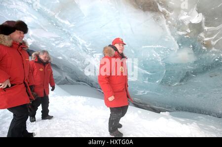 Alexandra Land, Russia. 29th Mar, 2017. Russian President Vladimir Putin enters an ice cave in the Polar Aviators Glacier as Prime Minister Dmitry Medvedev, left, and Defense Minister Sergei Shoigu, center, look on during a visit to Alexandra Land March 29, 2017 in Franz Josef Land archipelago, Russia. Putin is visiting the remote arctic islands to promote Russian claims to the regions natural resources. Credit: Planetpix/Alamy Live News Stock Photo