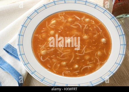 en plato redondo sopa de tomate con fideos y trozos de pescado Stock Photo