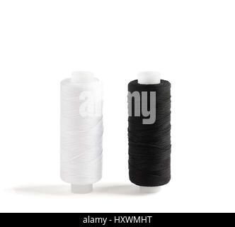 Two spools of cotton thread isolated on white. Black and white threads. Stock Photo