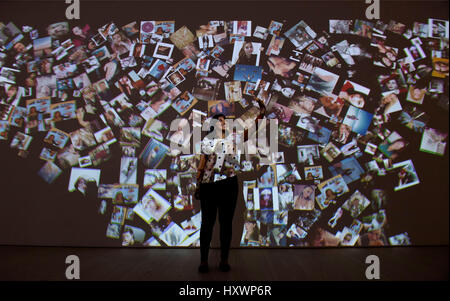 A visitor looks at a large-scale installation of selfie photographs during a press preview at the Selfie to Self-Expression exhibition at the Saatchi Gallery in London, which looks at the history of the selfie from portrait artists through to modern day selfies. Stock Photo
