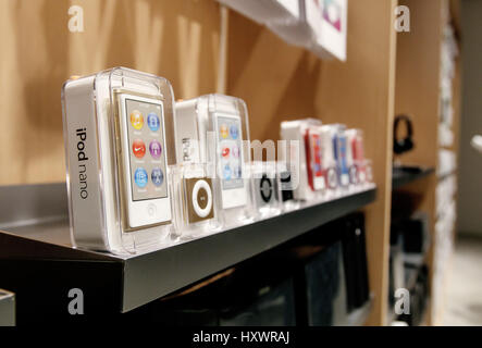 New iPod Shuffle and iPod Nano mp3 players stand on a shelf in an Apple store. Stock Photo
