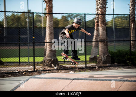 young boy skate boarding with helmet on Stock Photo