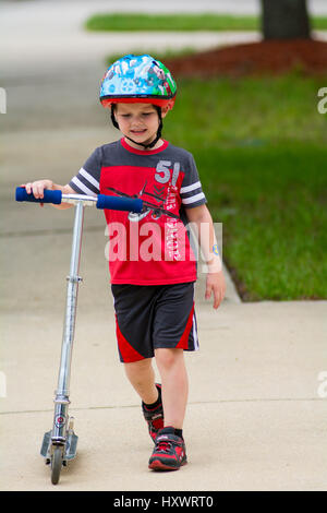 young boy riding scooter Stock Photo