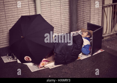 An old Chinese man is sleeping on a street in Hong Kong, China. Many homeless people don’t even earn enough for a subdivided flat. Stock Photo