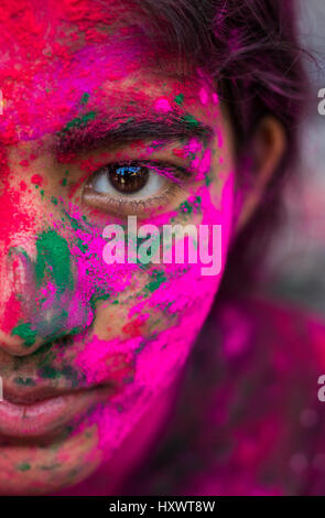 Half face portrait of a young girl covered with colors during the festival of colors, Holi in India. Stock Photo