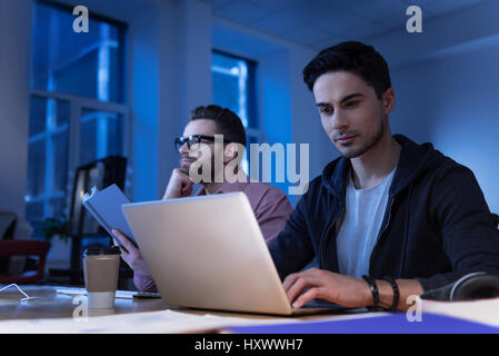 Positive intelligent programmer using his laptop Stock Photo