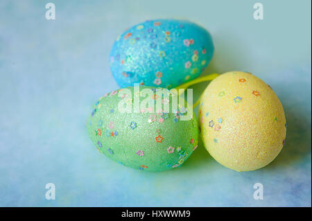 Three colorful handmade easter eggs on blue background Stock Photo
