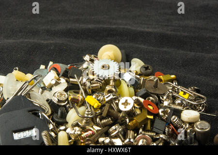 techno backgrounds - various bolts, screws, washers, nuts and other computer small fasteners on black fabric Stock Photo