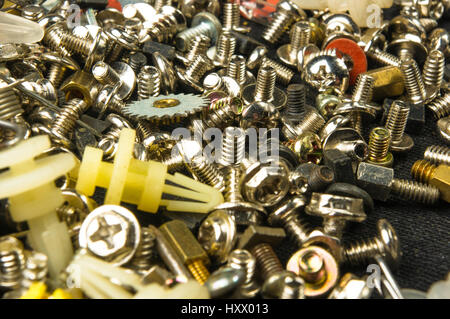 techno backgrounds - various bolts, screws, washers, nuts and other computer small fasteners on black fabric Stock Photo