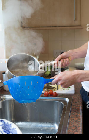 Spaghetti being sieved after being boiled in water. Stock Photo