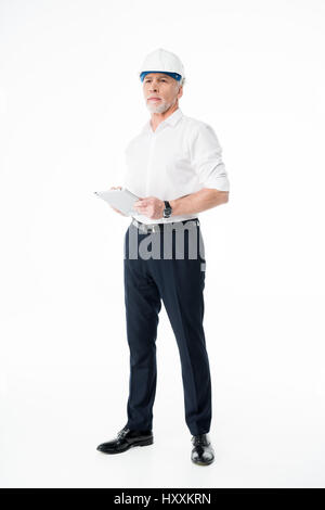 Mature male architect in hard hat using digital tablet Stock Photo