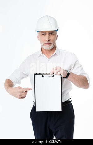 Mature male architect in hard hat holding blank clipboard Stock Photo