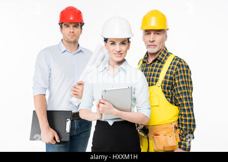 Two architects and mature workman looking at camera on white Stock Photo