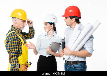 Two architects and mature workman discussing work Stock Photo