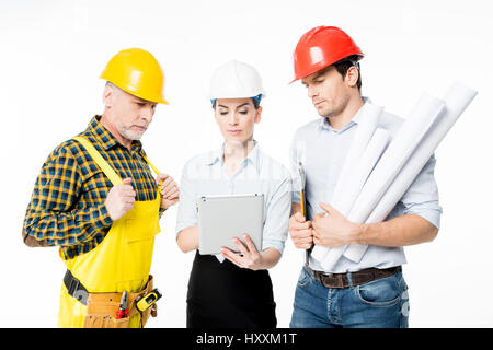 Two architects and mature workman looking at digital tablet Stock Photo