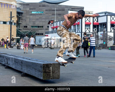 Wellington, New Zealand - February 10, 2017: Young skateboarder is doing skating tricks at the Wellington waterfront. Stock Photo