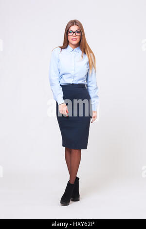 Full body studio shot of young beautiful business woman isolated on gray background. Stock Photo