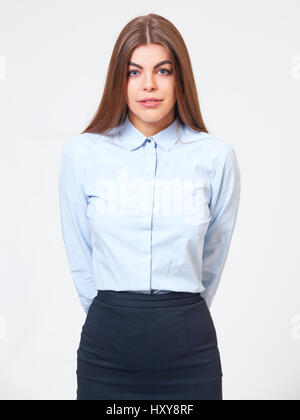 Studio portrait of young business woman standing in formal blue shirt and dark blue dress. Stock Photo